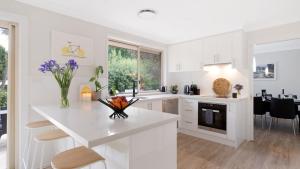 a kitchen with white cabinets and a white counter top at Soho House in Bowral