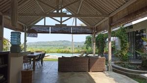 - un pavillon avec une table et un canapé sur la terrasse dans l'établissement Sunmoonstarvillas Yogyakarta, à Jarakan