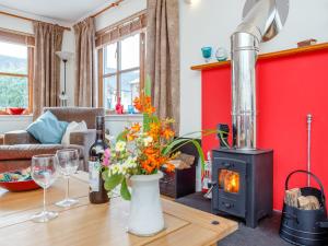 a living room with a wood stove and a table at Caldon Cottage in Cromarty