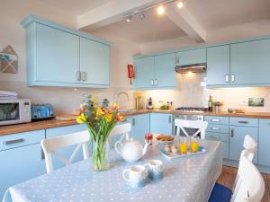 a kitchen with a table with a vase of flowers on it at The Lookout in Salcombe