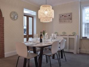 a dining room with a table and white chairs at Turnstone House in Gorleston-on-Sea
