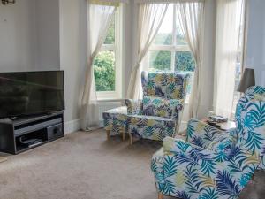 a living room with two chairs and a flat screen tv at Turnstone House in Gorleston-on-Sea