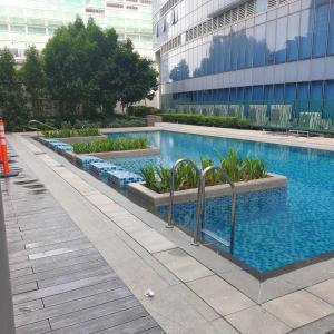 a swimming pool in the middle of a building at Cozy 1BR UPTOWN PARKSUITES Tower1 BGC in Manila