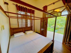 a bedroom with a bed and a large window at Fortress Gate Bungalow in Polonnaruwa