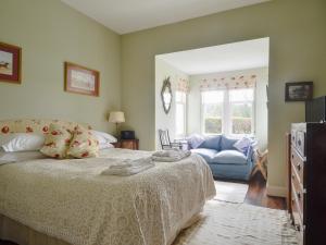 a bedroom with a bed and a couch at Cliff Cottage in Port Appin