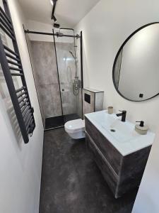 ein Badezimmer mit einem Waschbecken, einem WC und einem Spiegel in der Unterkunft CloudBase in Tukhlya