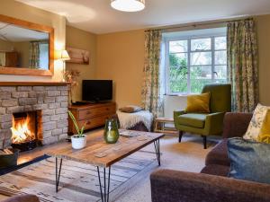 a living room with a couch and a fireplace at Barters Cottage in Chideock