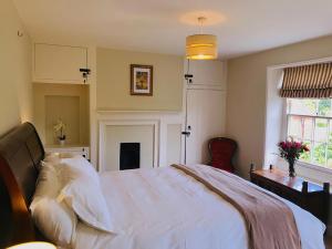 a bedroom with a bed with white sheets and a window at St Andrews in Tilmanstone