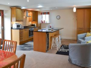 a kitchen and living room with a counter top at Stable Cottage in Chatton