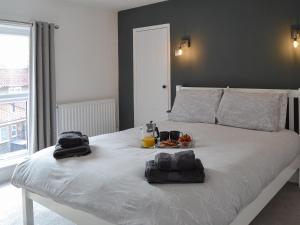 a white bed with a tray of food on it at Sea La Vie in Sheringham