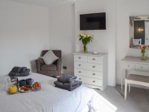 a bedroom with a bed with a tray of food on it at Sea La Vie in Sheringham