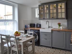a kitchen with a table and chairs and a sink at Sea La Vie in Sheringham