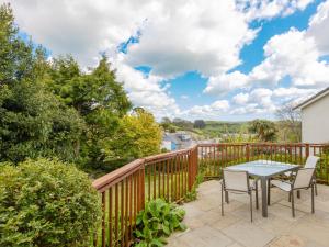 a patio with a table and chairs on a wooden deck at Rockvale 1 in Salcombe