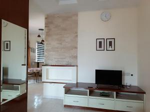 マスジッド・タナにあるHOMESTAY TG BIDARAの白い壁のリビングルーム(テレビ付)