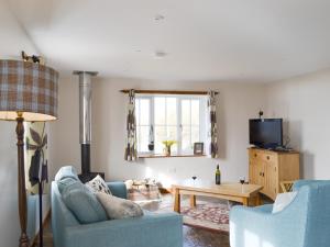 a living room with two blue chairs and a table at The Old Dye House in Hallin