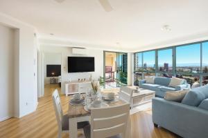 een woonkamer met een tafel, een bank en een tv bij Sun City Spacious Sleeps 4 in Gold Coast