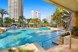 een zwembad in een resort met palmbomen en gebouwen bij Sun City Spacious Sleeps 4 in Gold Coast