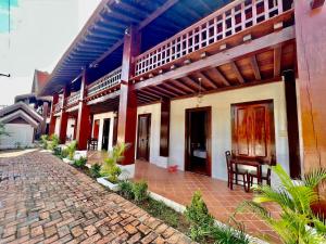 a house with a brick walkway in front of it at Lakhang Thong Hotel in Luang Prabang
