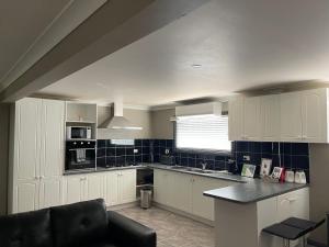 a kitchen with white cabinets and a black counter top at Cottage in the Country in Tumut