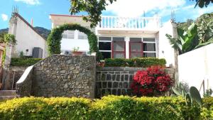 een wit huis met een stenen muur en een boog bij CASADUNN Next to Sababa Resort in San Pedro La Laguna