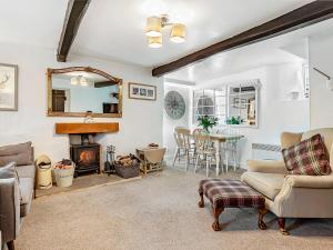 a living room with a fireplace and a table at Wellside Cottage in Starbotton