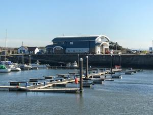 einen Yachthafen mit Booten im Wasser mit einem Gebäude in der Unterkunft Golwg Y Mor in Burry Port