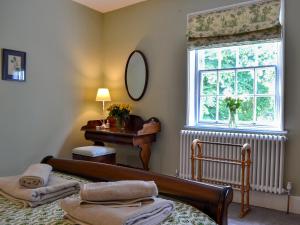 een slaapkamer met een bed, een raam en een piano bij Oxtobys Upstairs in York