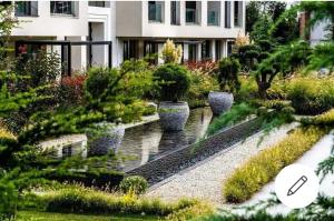 a garden with a fountain and plants in front of a building at ALLURE VARNA studios in Saints Constantine and Helena