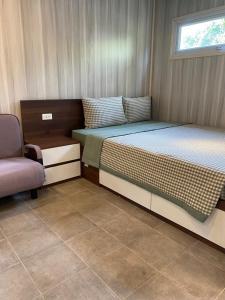 ein kleines Schlafzimmer mit einem Bett und einem Stuhl in der Unterkunft Halo Retreat in Hòa Bình