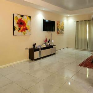 a living room with a flat screen tv on the wall at Spacious & Spotless new house, 4 BRs in Roatan
