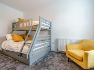 a bedroom with a bunk bed and a yellow chair at Wynbec Cottage in Esh