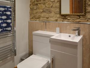 a bathroom with a sink and a toilet at The Barn in Staintondale