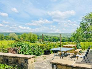 a table and chairs on a patio with a view at Lane House in Threshfield