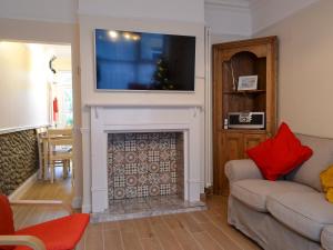 a living room with a fireplace with a tv above it at Scira in Sheringham
