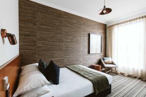 ein Hotelzimmer mit einem Bett und einer Ziegelwand in der Unterkunft The State Hotel in New Plymouth