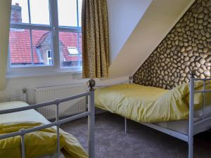 a bedroom with two bunk beds and a window at Scira in Sheringham