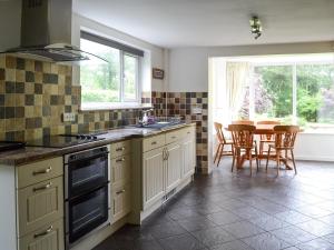 cocina con fregadero y mesa con sillas en Sunny Beck, en High Nibthwaite