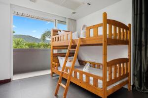 a bedroom with two bunk beds and a balcony at The Fairways Villas - 4 bedroom for 10 guests - 7kms to Patong beach in Kathu
