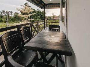 eine Veranda mit einem Tisch und Stühlen auf dem Balkon in der Unterkunft D'Village Homestay Kota Bharu in Kota Bharu