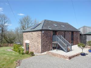 a brick building with a staircase in a yard at The Cow Shed in Tiverton