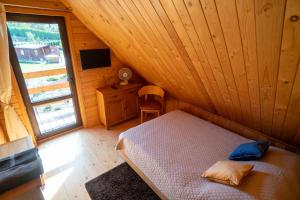 a bedroom with a bed in a wooden cabin at Uroczysko Trzyrzeczki in Dąbrowa Grodzieńska-Wieś