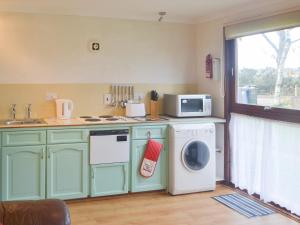 a kitchen with a washing machine and a microwave at Chalet 1 - Uk30302 in Tore