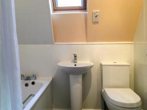 a white bathroom with a sink and a toilet at Heather Lodge in Glenurguhart