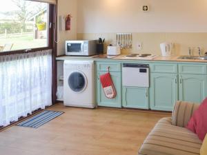 a kitchen with a washing machine and a microwave at Chalet 1 - Uk30302 in Tore