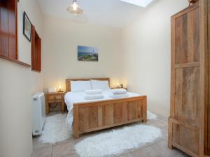 una camera da letto con un grande letto e un tavolo in legno di The Old Forge a Beesands