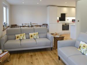 a living room with a couch and a table at Crofters Cottage in Rothbury