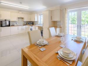 uma cozinha e sala de jantar com uma mesa de madeira e cadeiras em Dawson Park 1 - Uk12660 em Mablethorpe