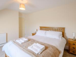um quarto com uma cama branca com duas toalhas em Dawson Park 1 - Uk12660 em Mablethorpe
