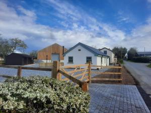 a home with a wooden fence and a house at Pointer Cottage in Preesall