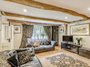 a living room with a couch and a tv at Yew Tree Farm in Charing